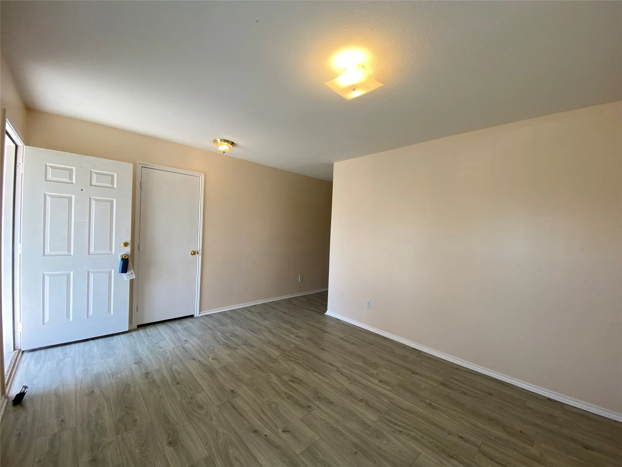 Spare room featuring dark wood-style floors and baseboards