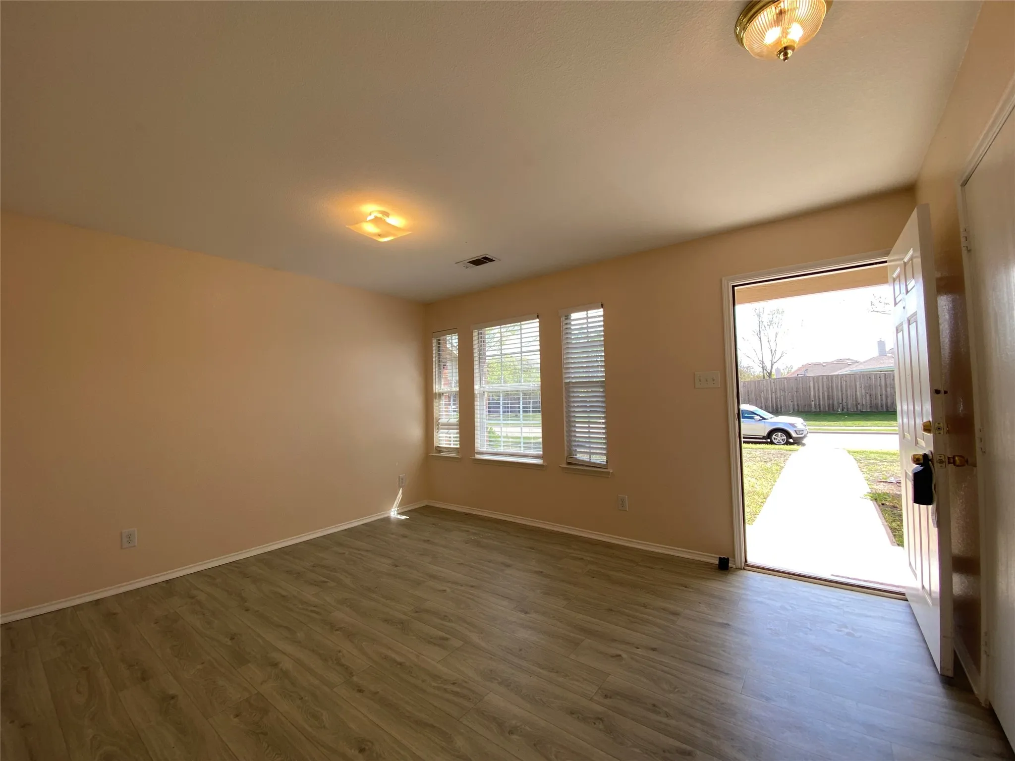 Foyer entrance with baseboards, visible vents, and dark wood-style flooring