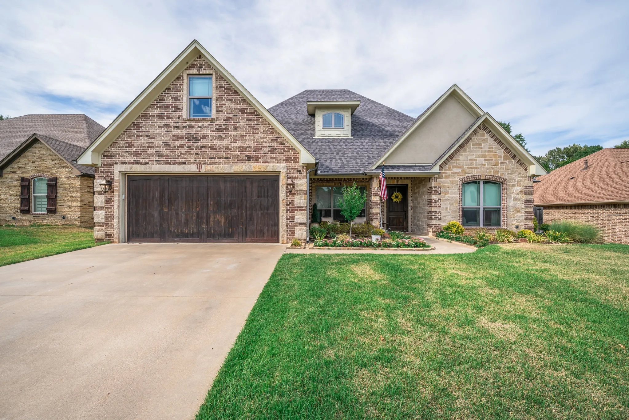 Brick and stone facade with a dark wood-finish garage door