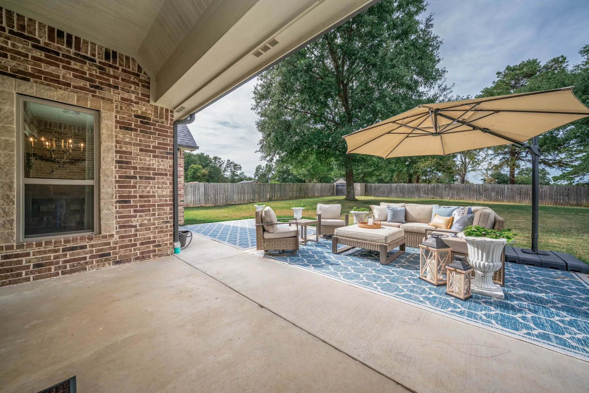 Covered concrete patio with a brick exterior