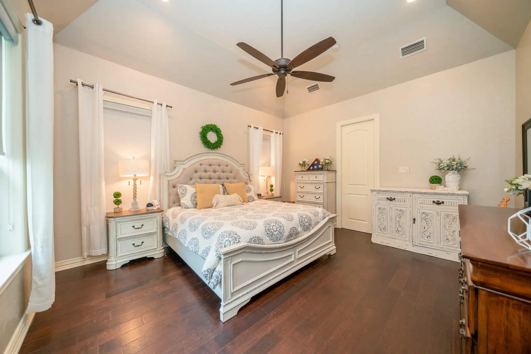 Vaulted ceiling, recessed lighting, ceiling fan, wood-finish flooring, and a white interior door