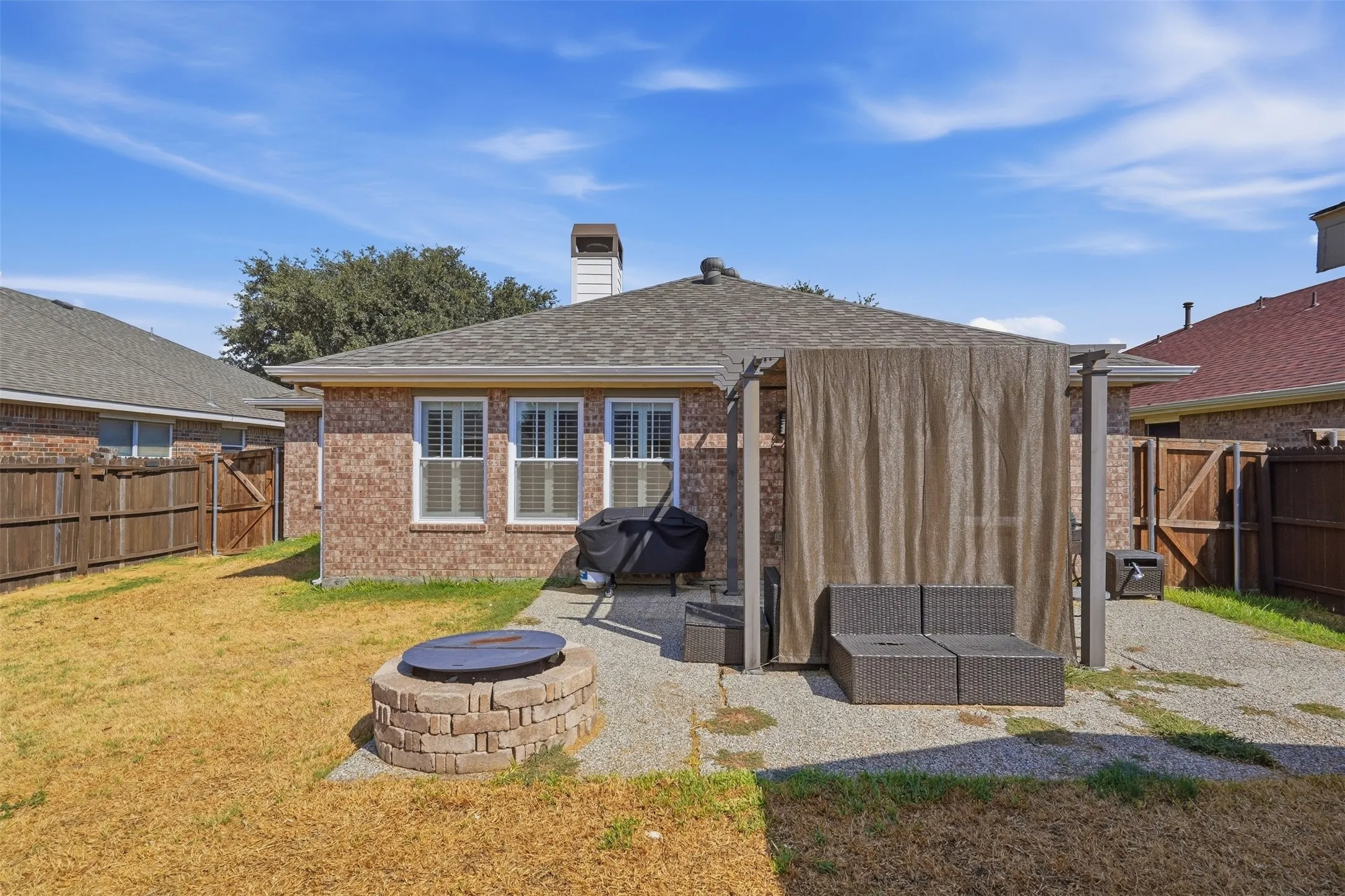 Brick exterior, shuttered windows, paver patio, built-in fire pit, pergola