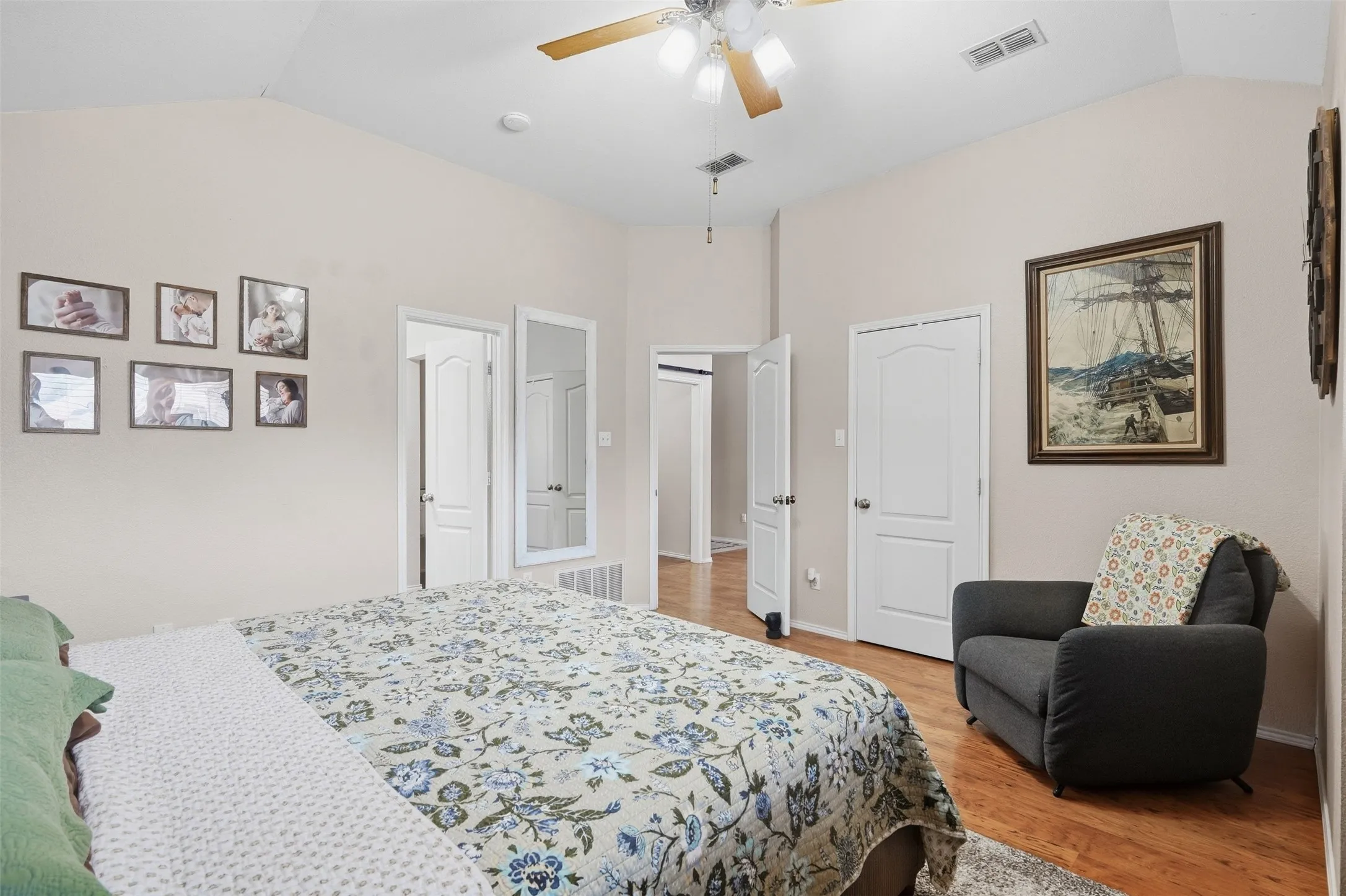 Vaulted ceiling with a ceiling fan, light-toned wall paint, wood-finish flooring, and a window with horizontal blinds