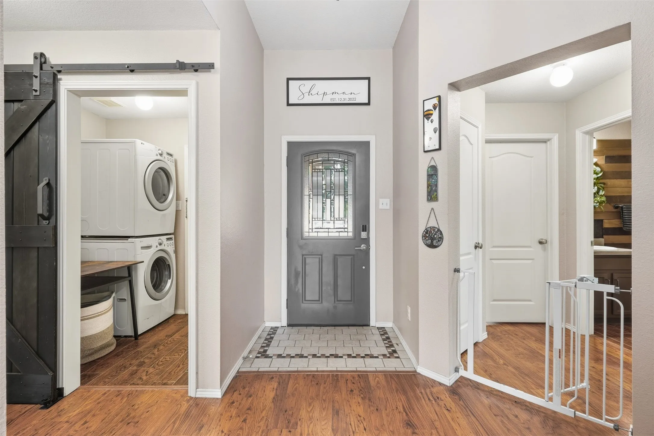 Entryway featuring wood-finish flooring, a decorative front door with opaque glass, and a tiled mat