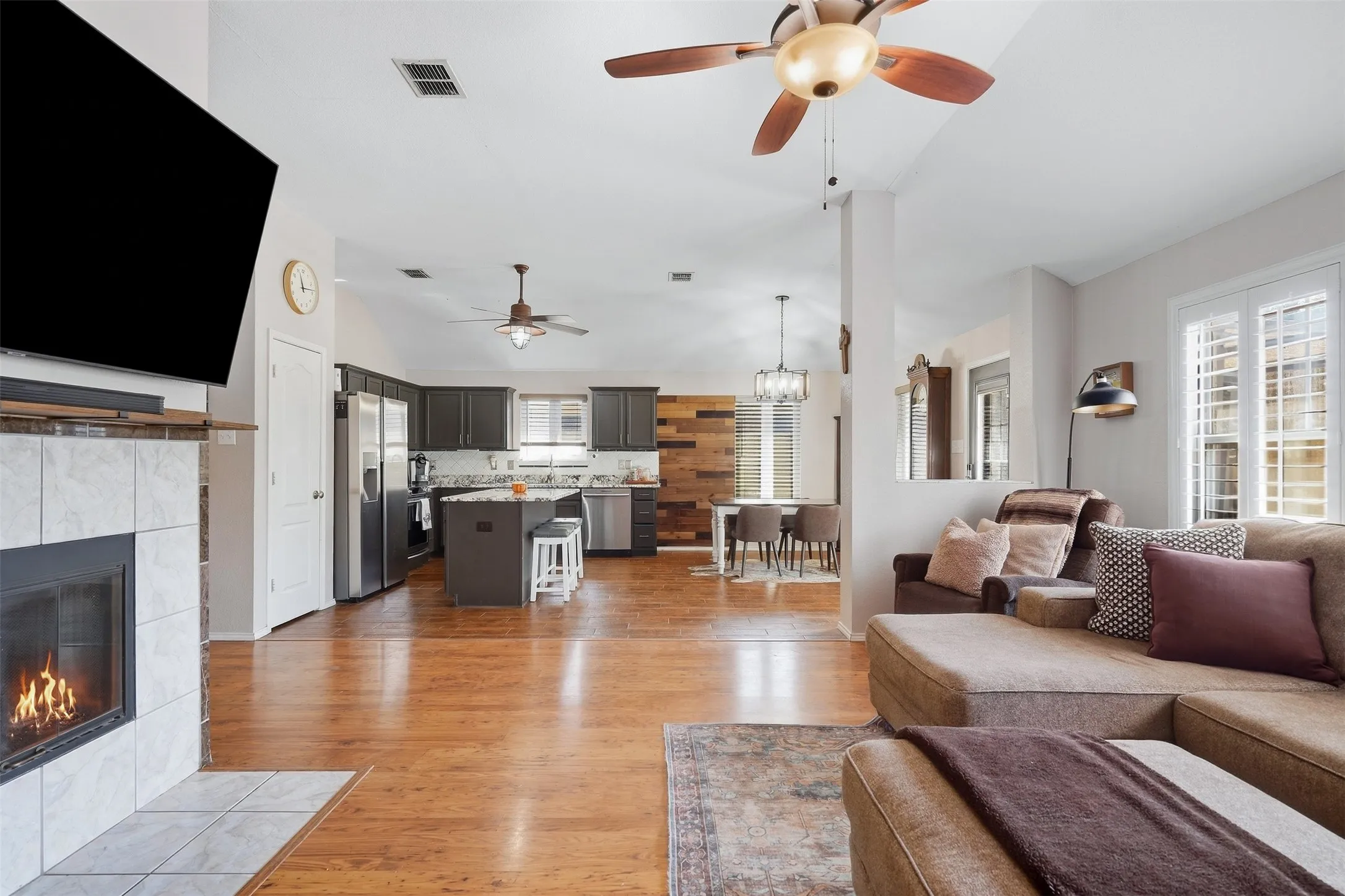 Wood-finish flooring, vaulted ceilings, and a tile-surround fireplace