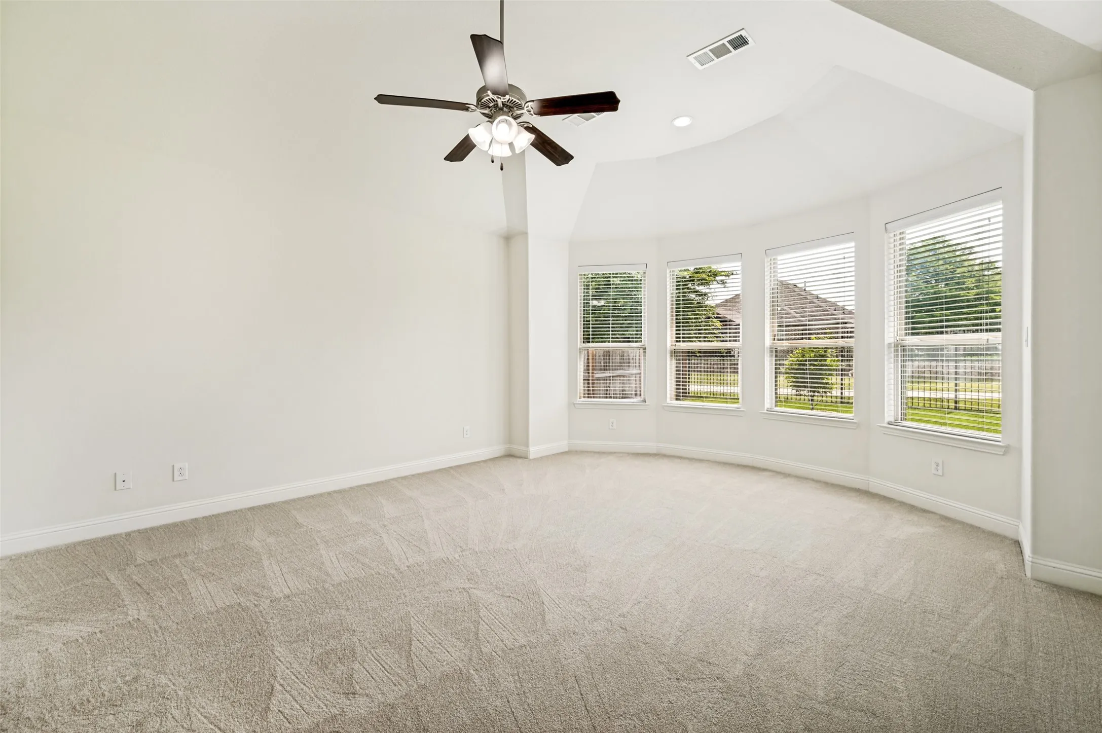 Primary master with new carpet & bay windows overlooking backyard