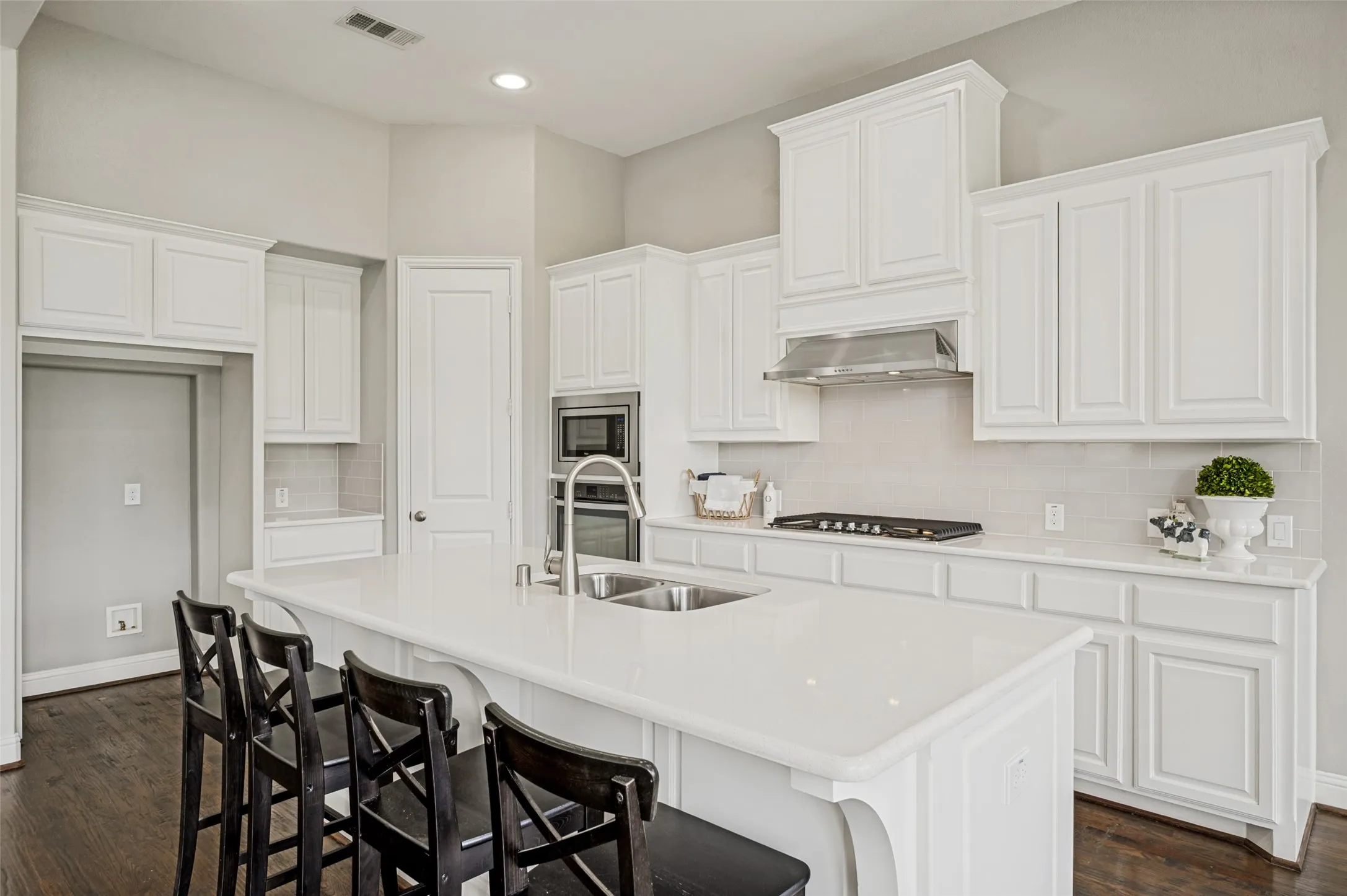 Kitchen with large quartz island and walk in pantry