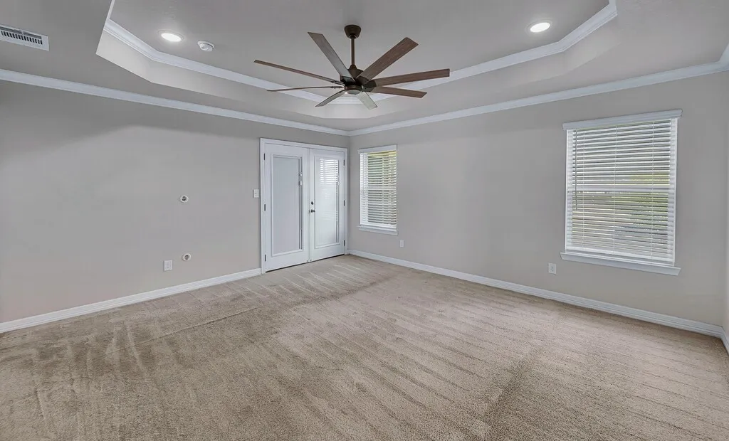 Recessed lighting, tray ceiling, ceiling fan, carpeted flooring, and a pair of French doors