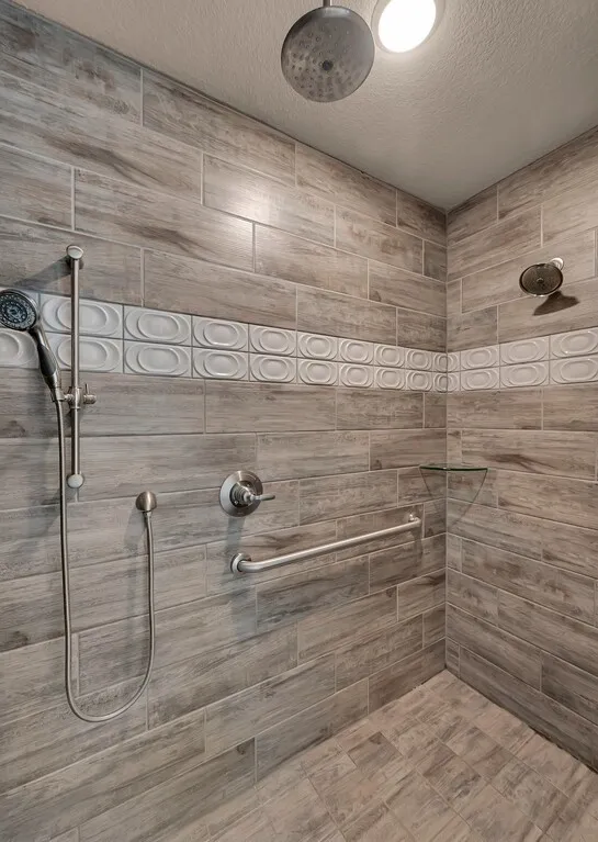 Walk-in shower featuring wood-look tile, decorative accent tile, a rain showerhead, and a handheld shower attachment