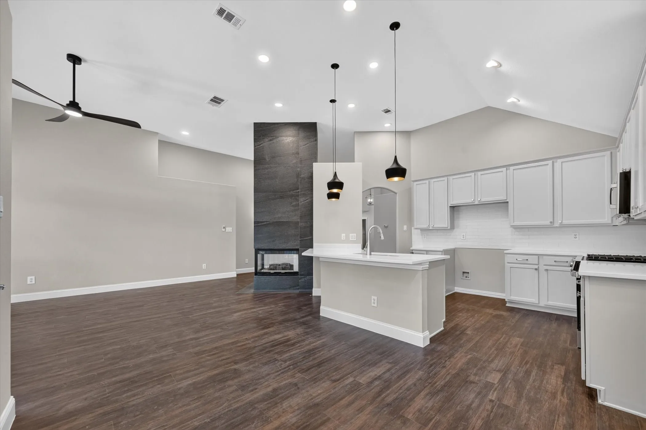 Vaulted ceilings, a contemporary fireplace, and wood-finish flooring