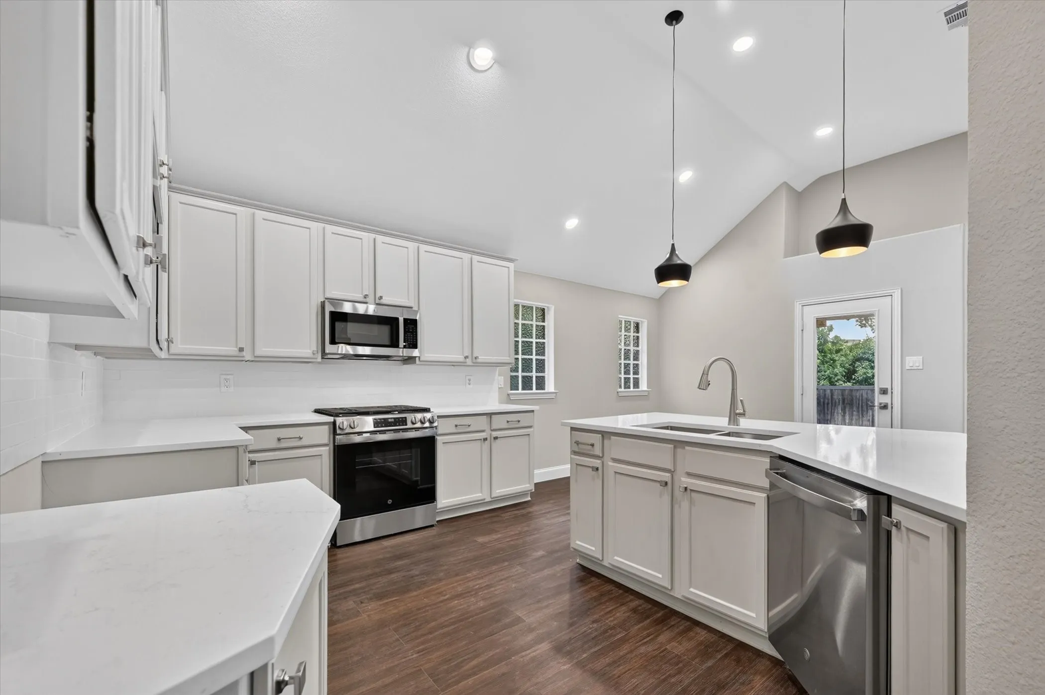 Kitchen featuring white shaker cabinetry, white countertops, stainless steel appliances, and wood-finish flooring