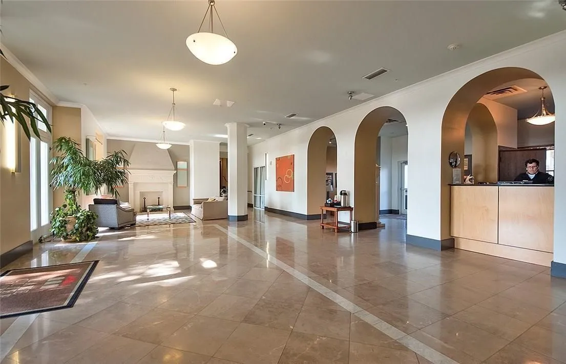 Tiled flooring, arched doorways, a built-in reception desk, pendant lighting, and a decorative fireplace