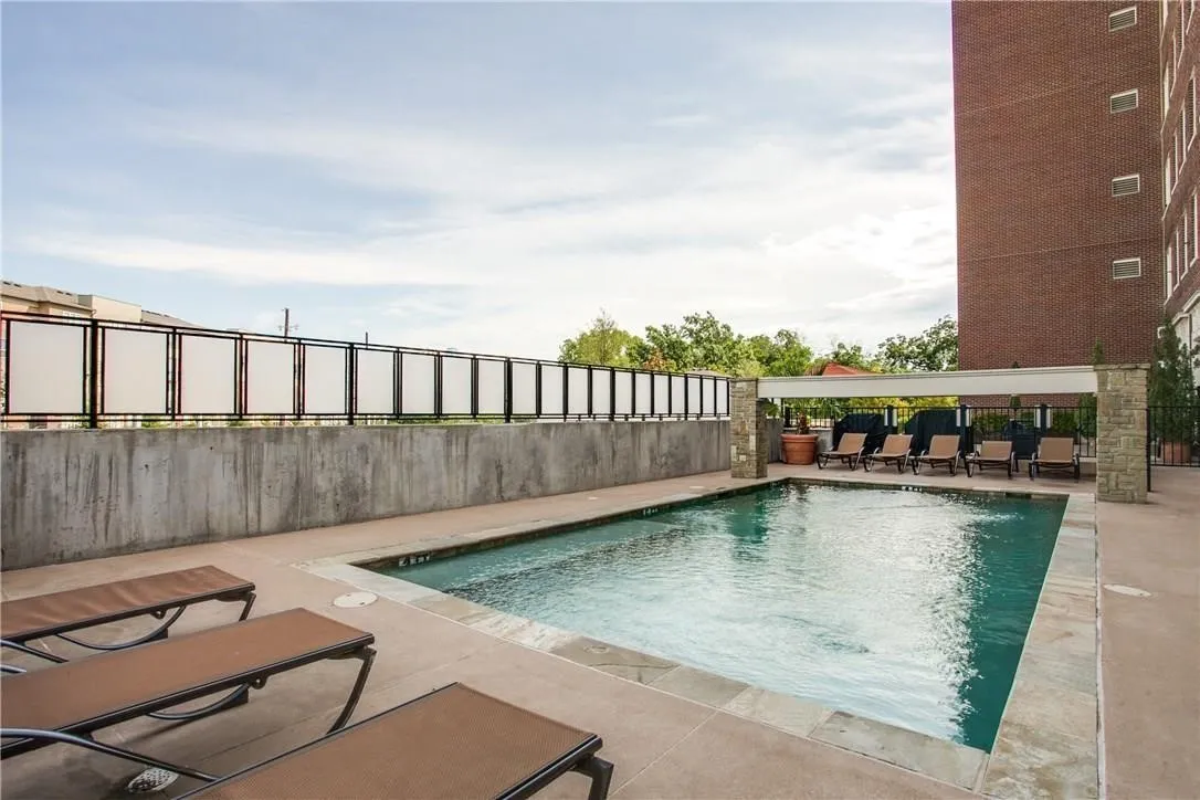 Outdoor swimming pool with a stone coping and a concrete surround