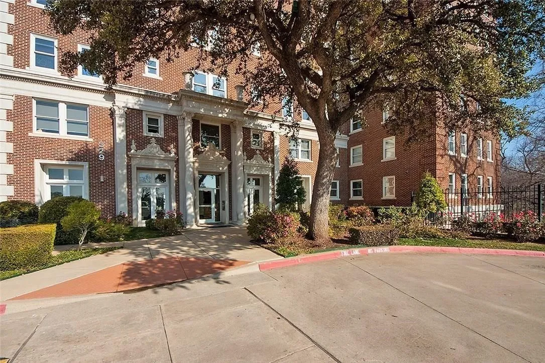 Brick exterior with stone accents, mature landscaping, and a paved entryway