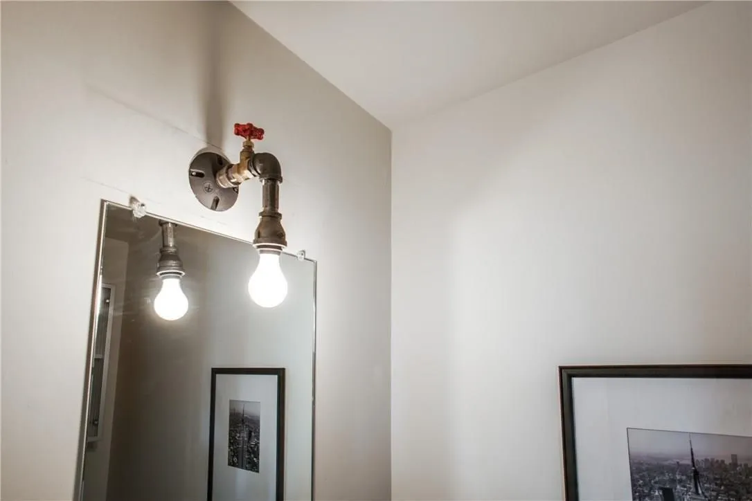 Industrial-style wall sconce featuring pipe fittings and an exposed bulb