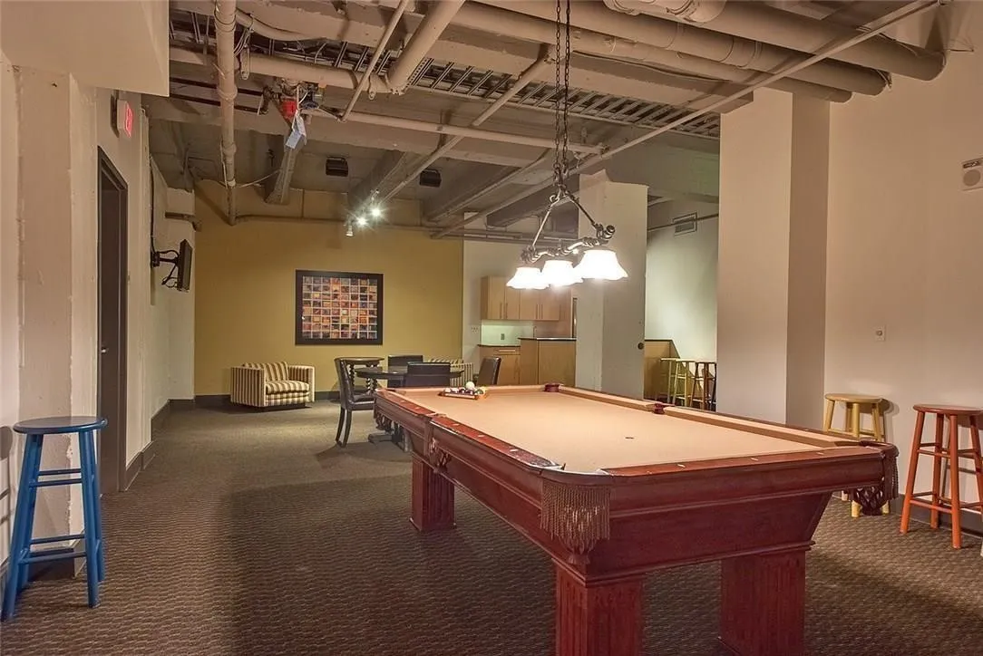 Recreation area featuring a billiard table, exposed ceiling pipes, track lighting, and a built-in wet bar with wood-finish cabinetry