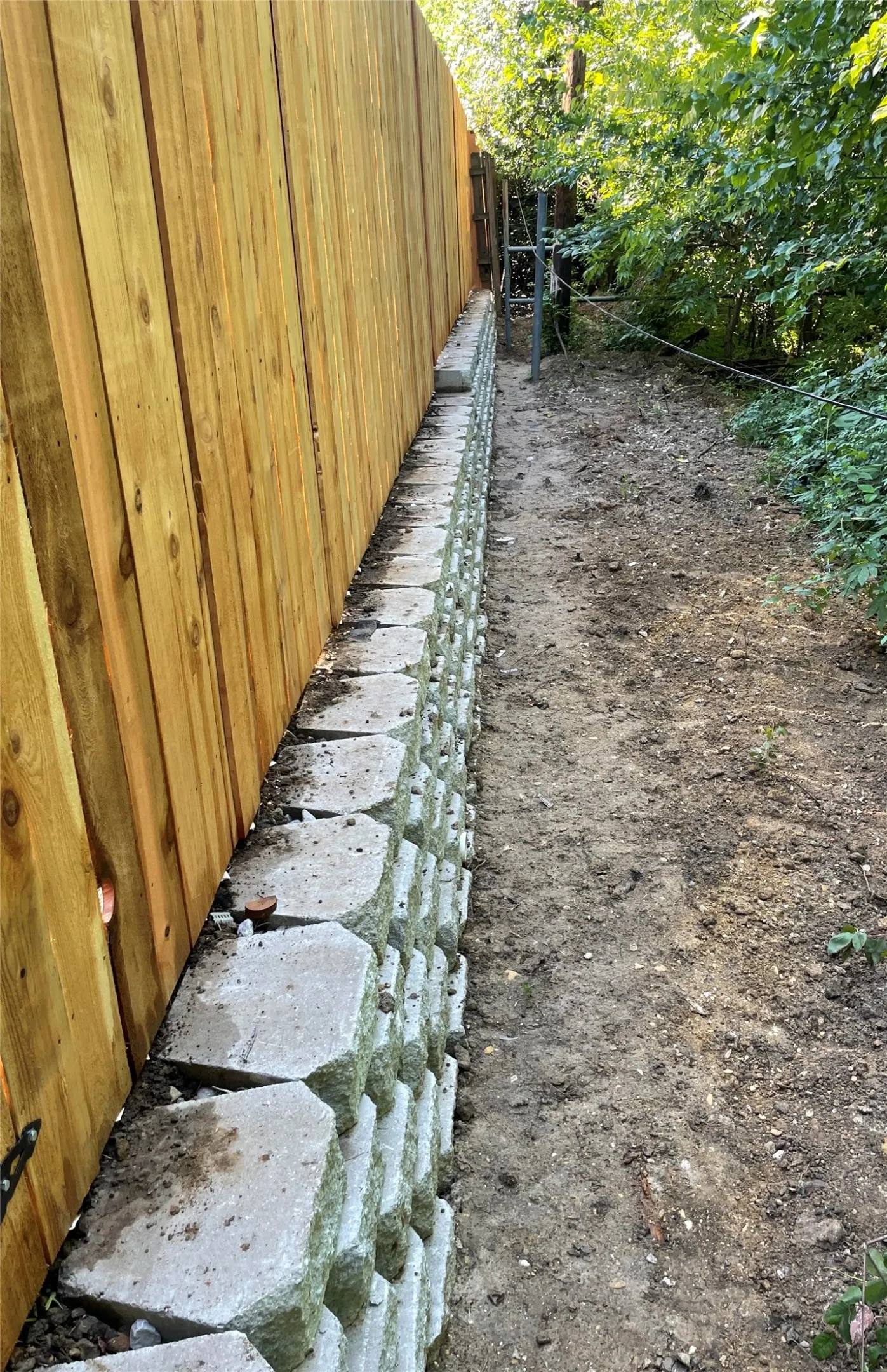 Wood privacy fence with an adjacent retaining wall