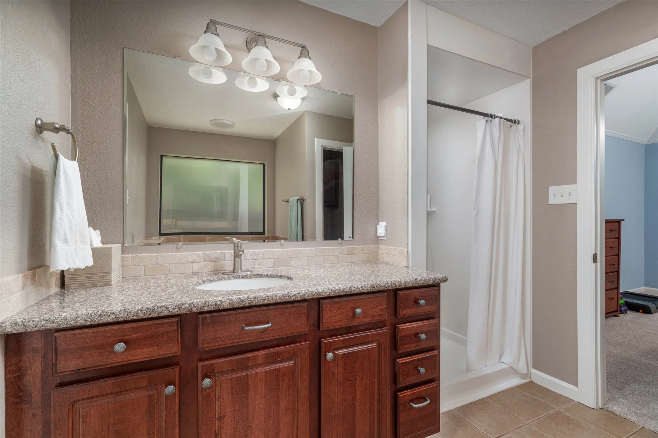 Jacuzzi walk in shower , granite-style countertop, and wood-finish cabinetry