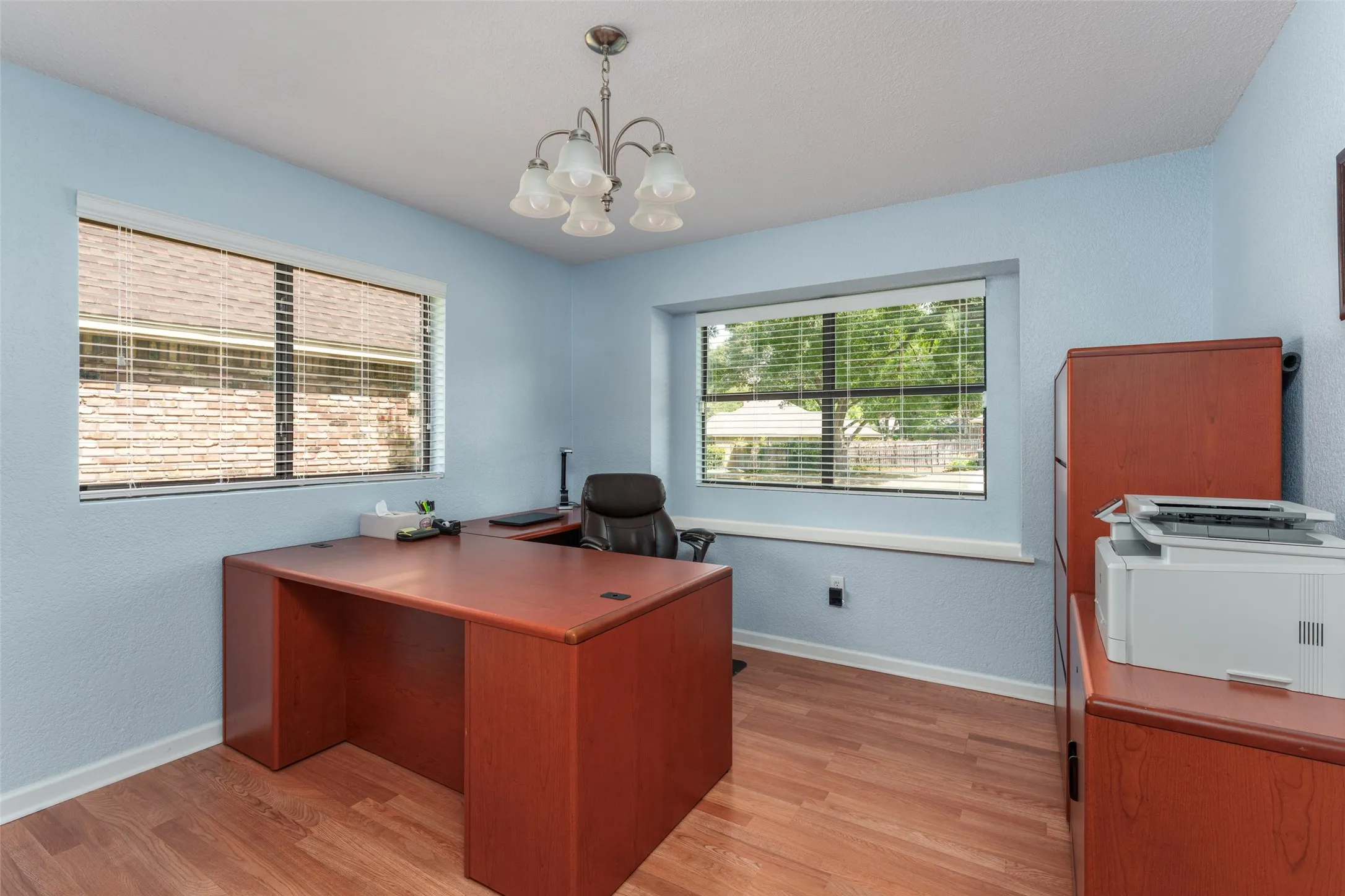 Features a window seat and motorized blinds. Wood-finish flooring with light blue walls and white trim