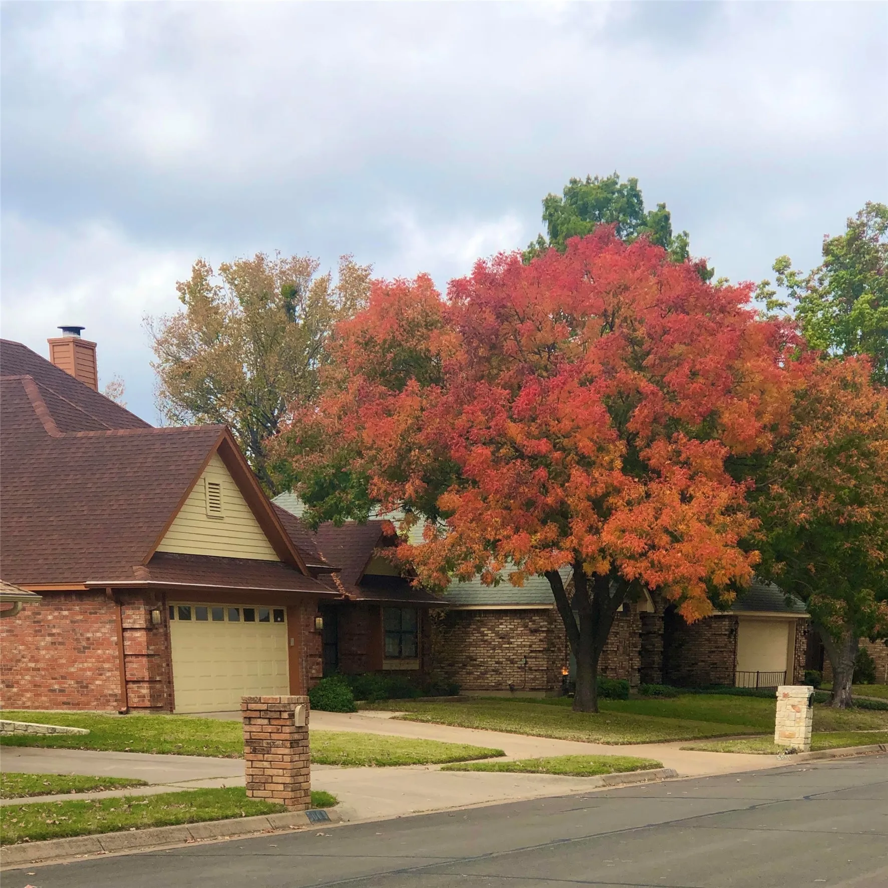 Brick exterior with a shingle roof and an attached garage