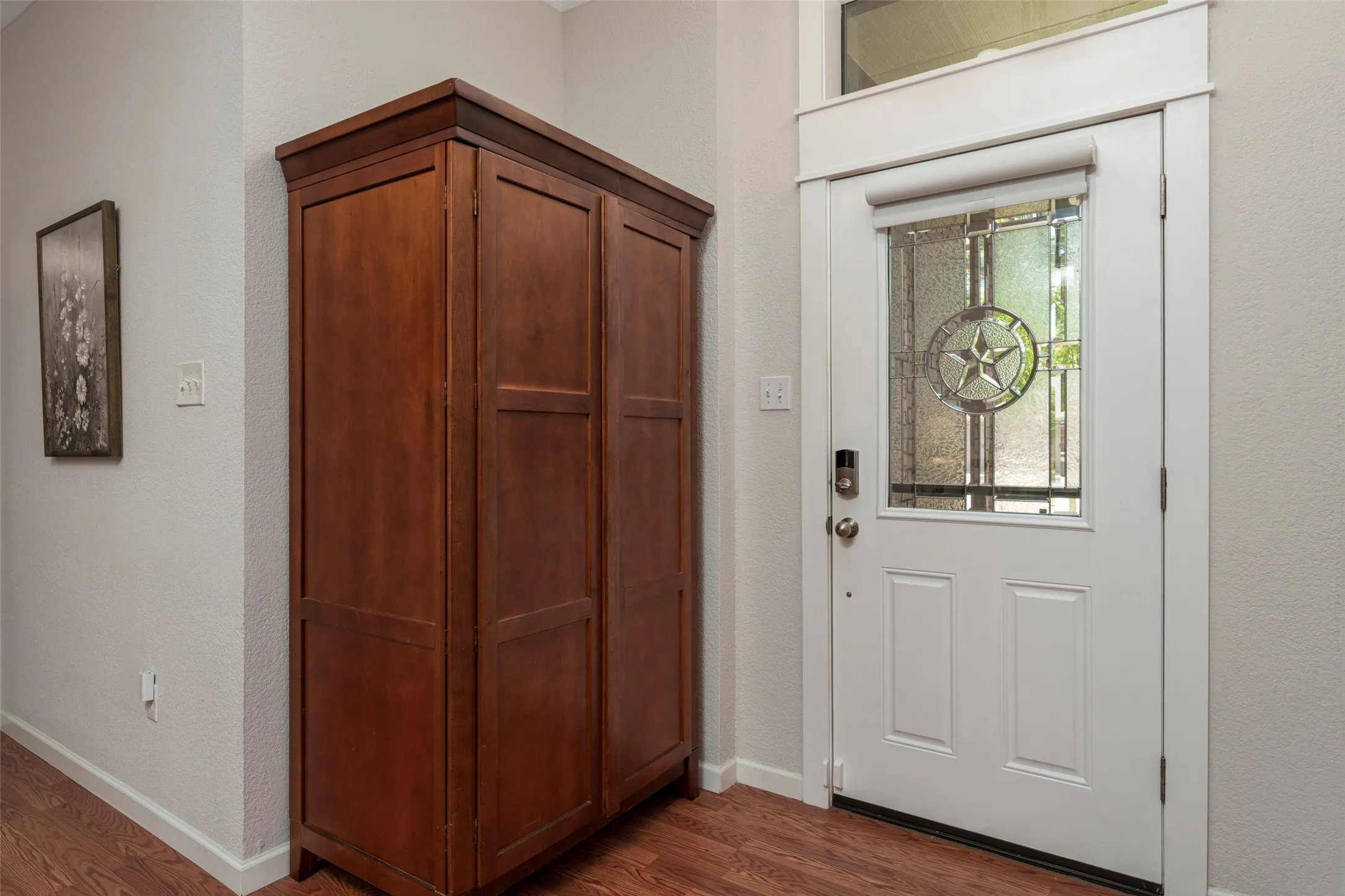 White paneled entry door with decorative glass inlay and transom window
