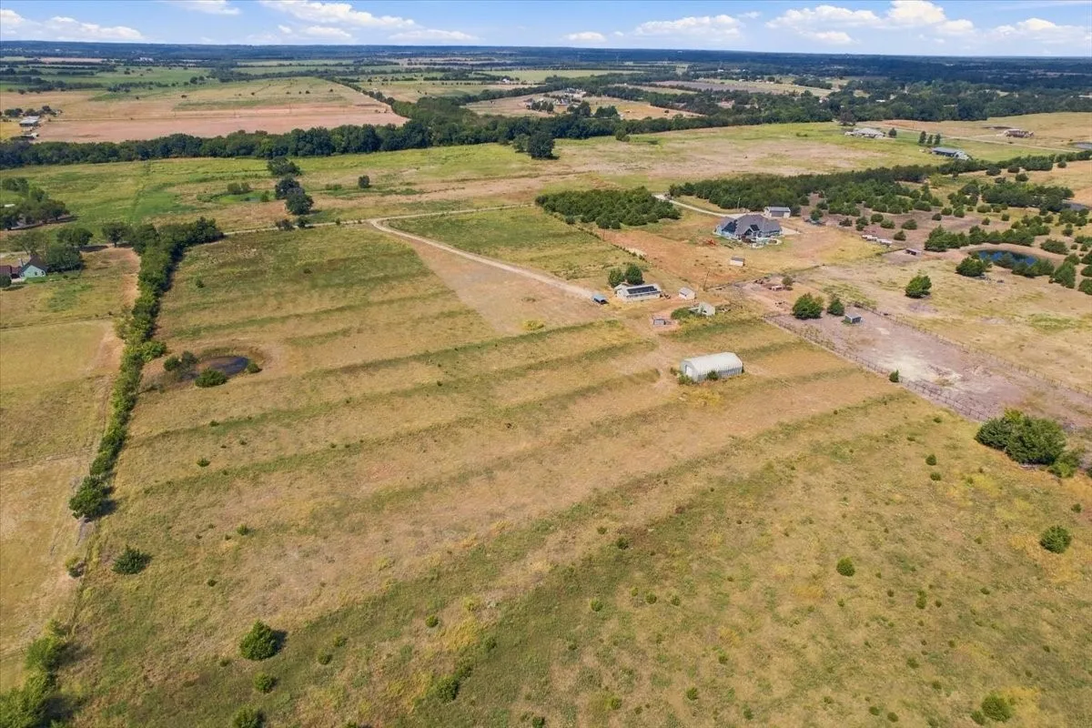 Aerial view includes surrounding nearby properties.  (Additional land of 23.935 acres shown in aerial photo between this listing and tree line is also available in MLS#20986552).