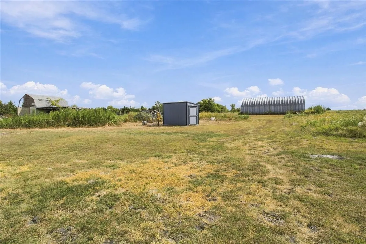 Old barn (far left), gray chicken coop/run; 30X50 metal shop with concrete slab; roll up door; exterior door