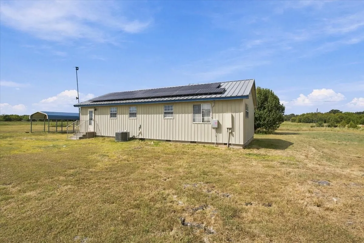 Back view of home with metal roof, solar panels
