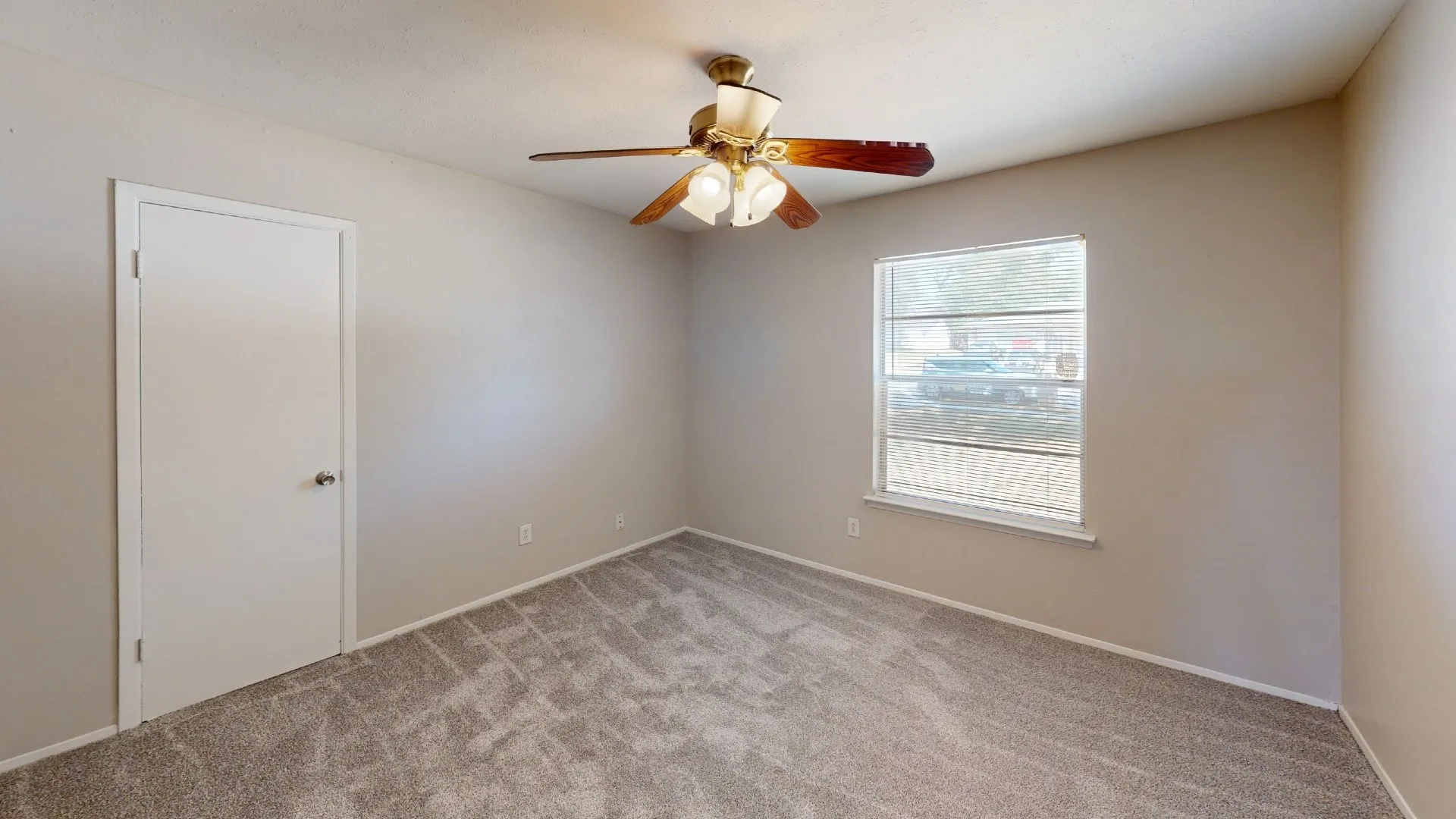 Neutral wall paint, ceiling fan, white trim, and light gray patterned carpet