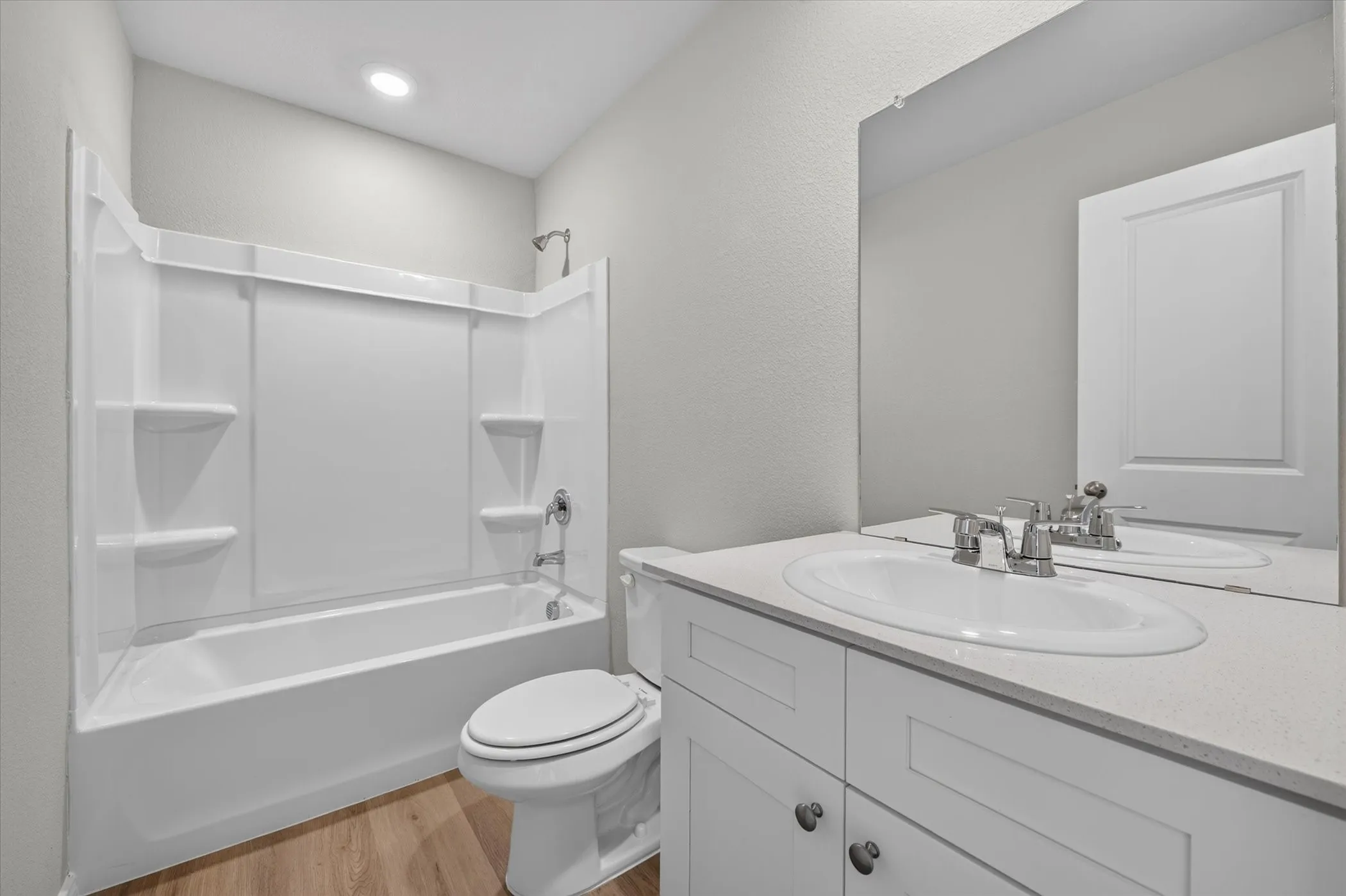 White vanity with a light countertop, undersink cabinetry, and a chrome faucet