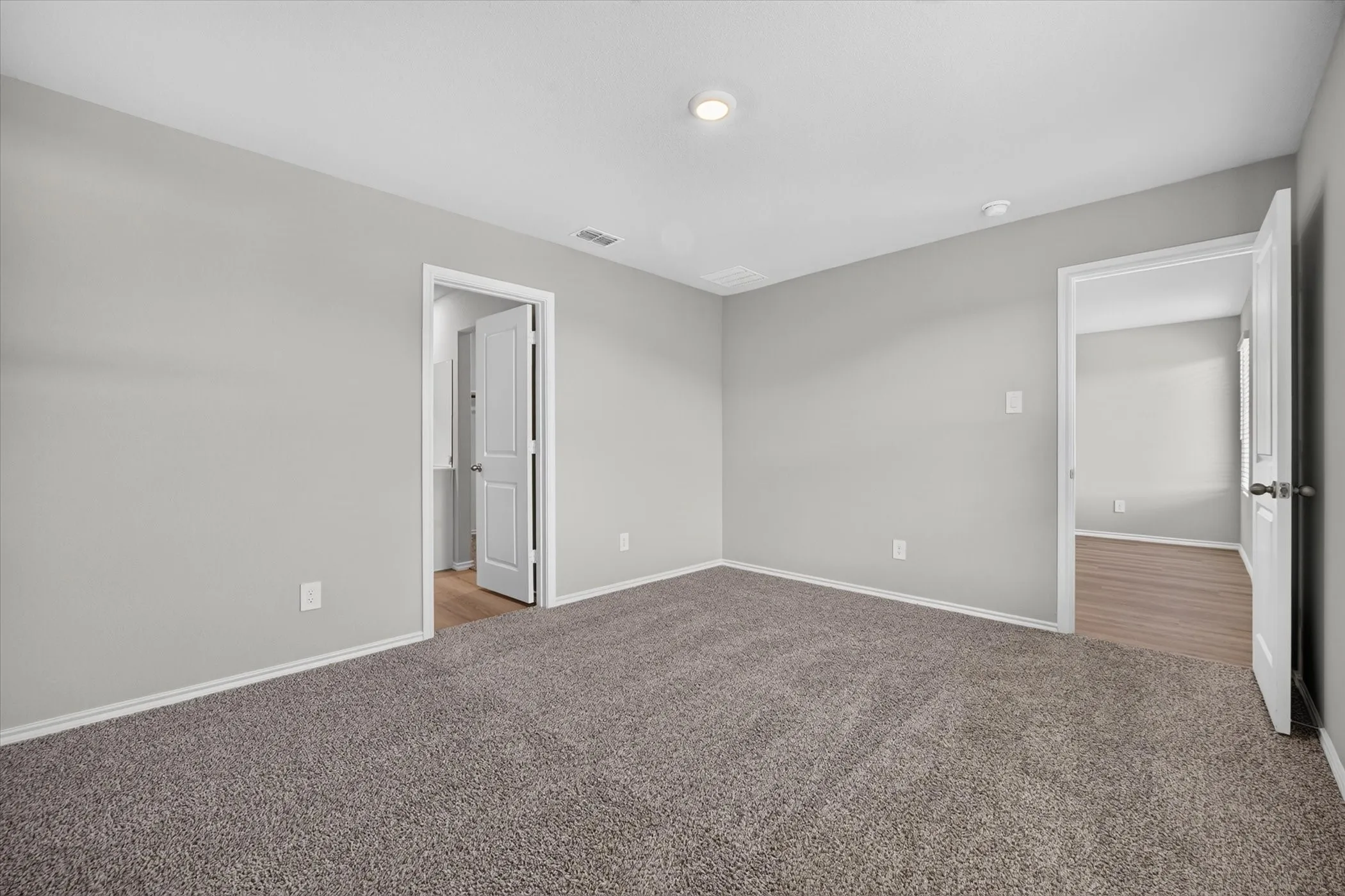 Plush carpet flooring, neutral paint palette, recessed ceiling lighting, and white trim