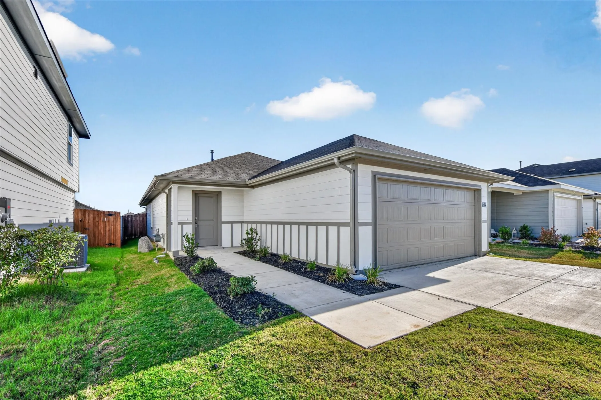 Single-story residence featuring a two-car garage, concrete driveway, and front landscaping