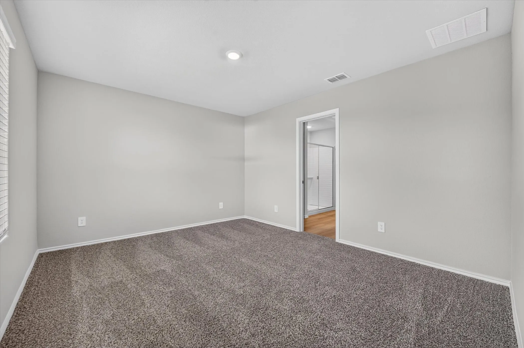 Vaulted ceiling room with recessed lighting and neutral gray walls