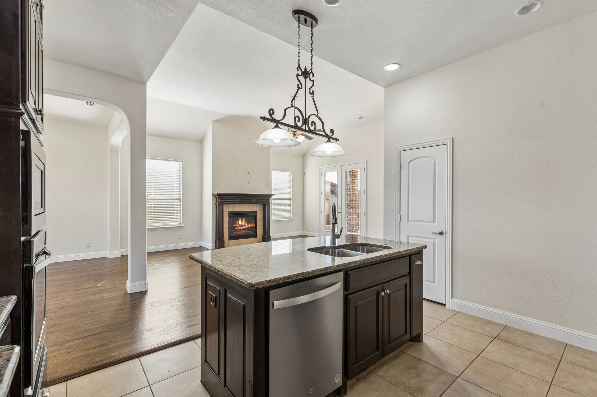 Kitchen island with granite countertop, double basin sink, and integrated stainless steel dishwasher