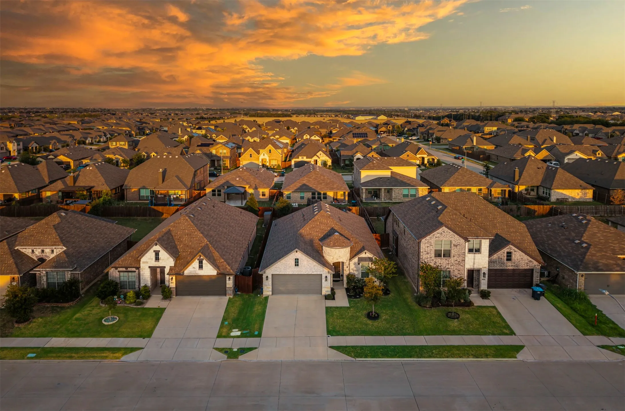 Residential neighborhood with varied architectural styles, asphalt shingle roofs, and concrete driveways