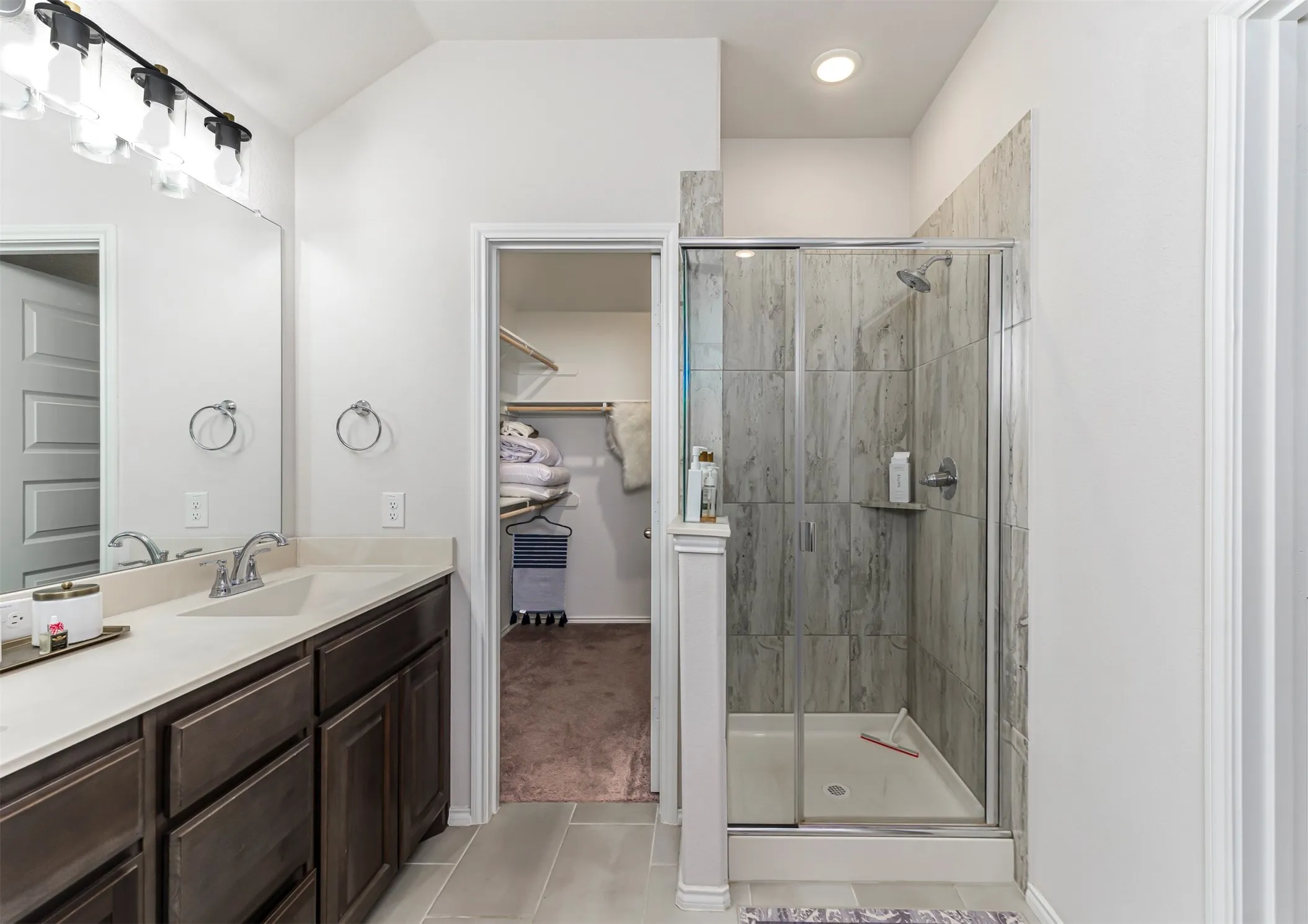Double vanity with dark wood-finish cabinetry and light-toned countertops