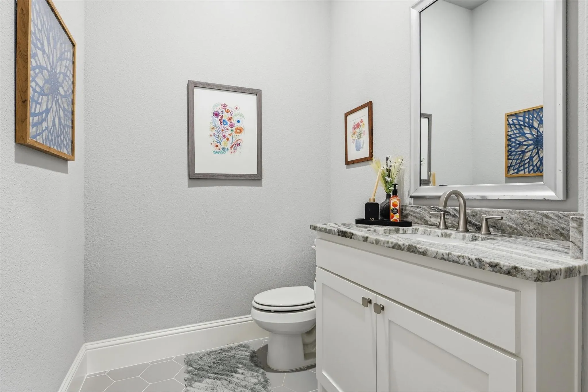 Vanity with a granite countertop, undermount sink, and brushed nickel faucet