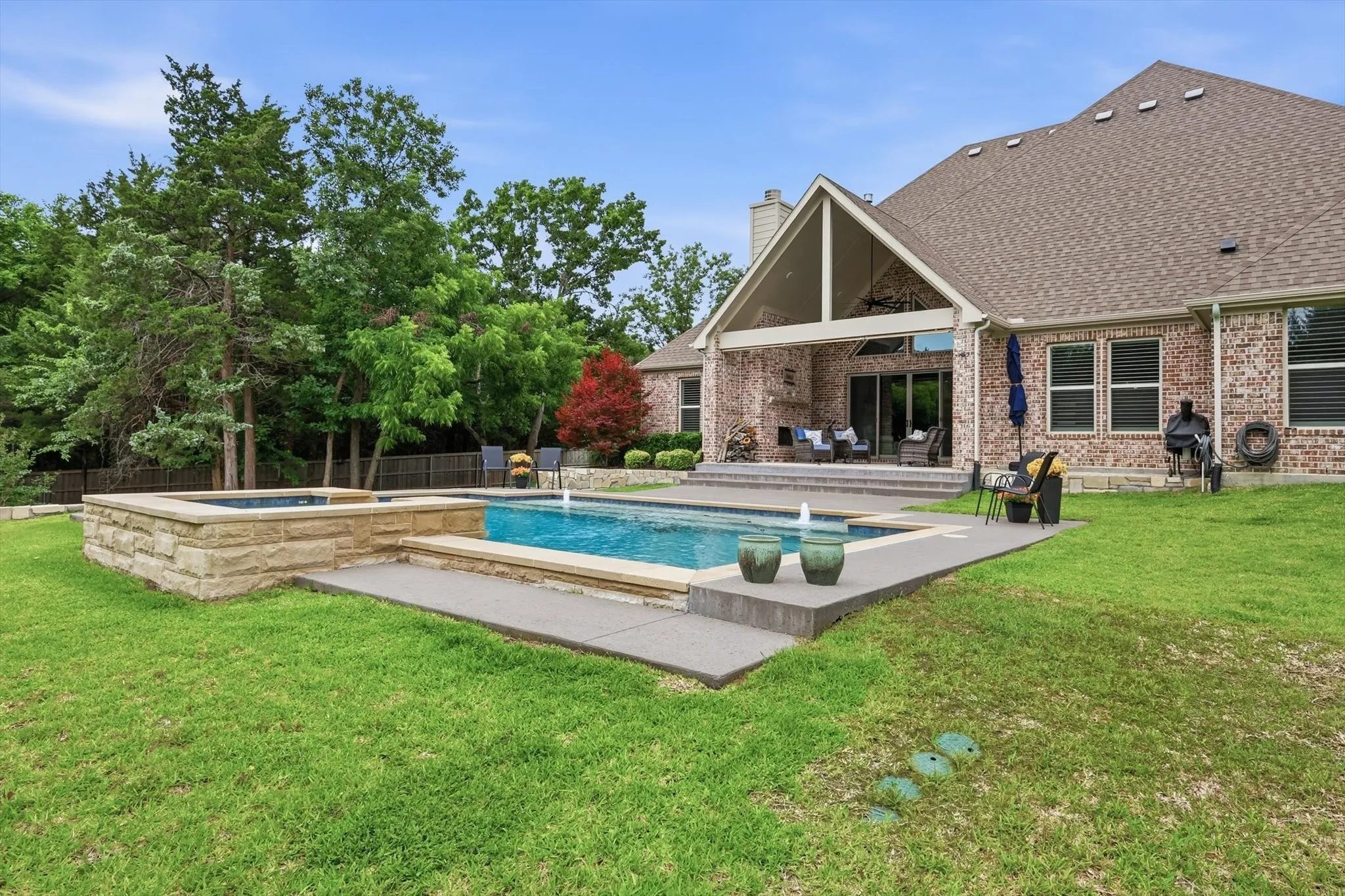 Brick exterior residence with a gabled roofline and an expansive backyard