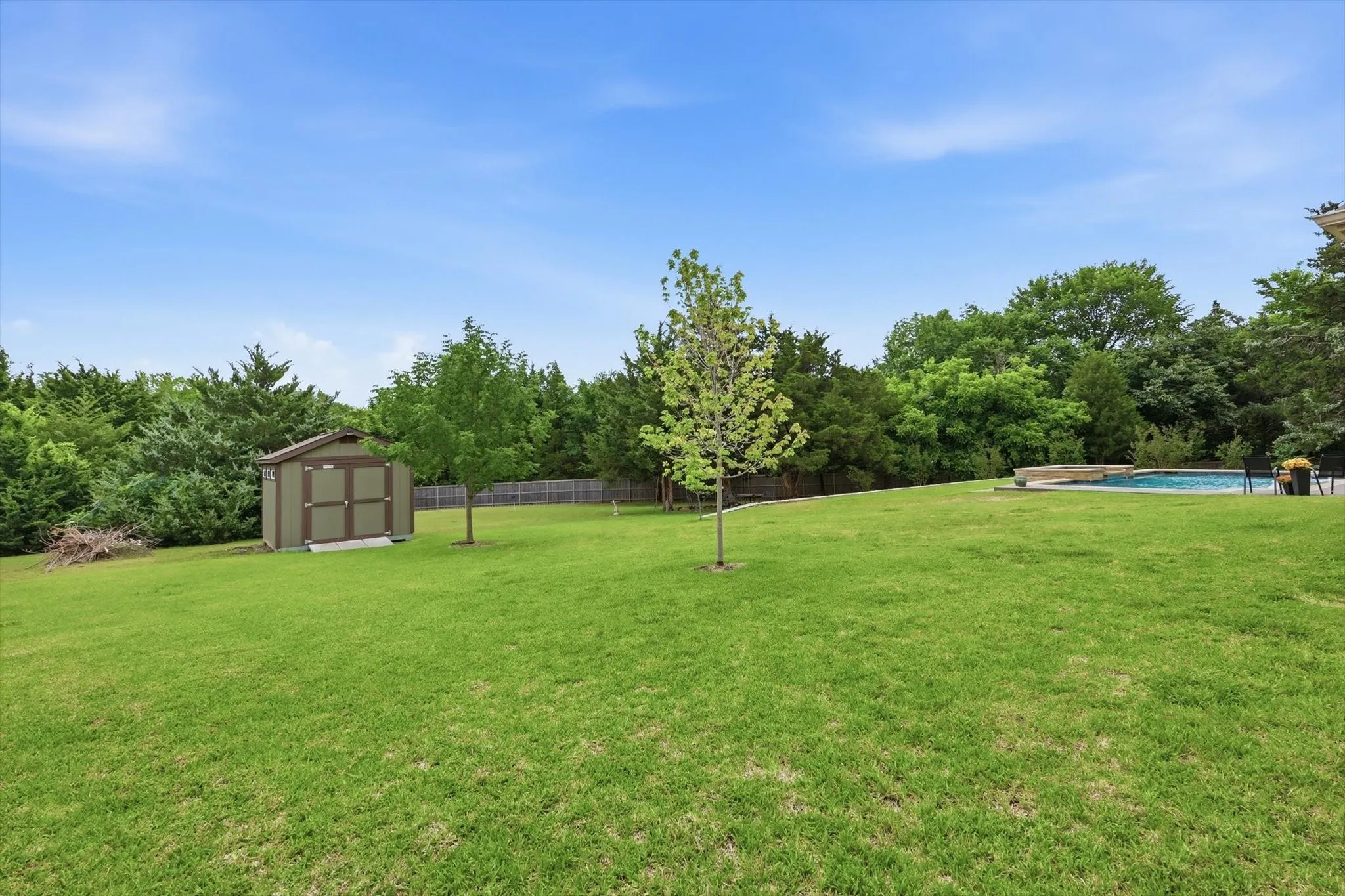 Expansive green lawn with a swimming pool and spa