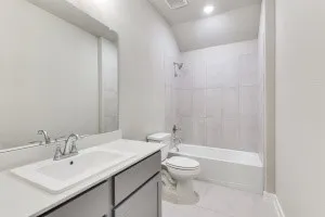 Vanity with integrated sink, chrome faucet, and storage cabinetry