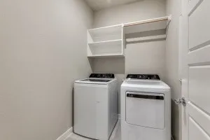 Dedicated laundry area featuring white shelving and a hanging rod