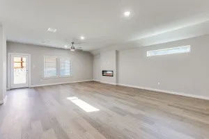 Spacious living area featuring wood-finish flooring, recessed lighting, and a modern built-in fireplace