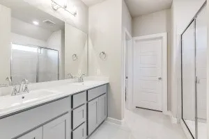 Dual vanity with undermount sinks, chrome fixtures, and grey cabinetry