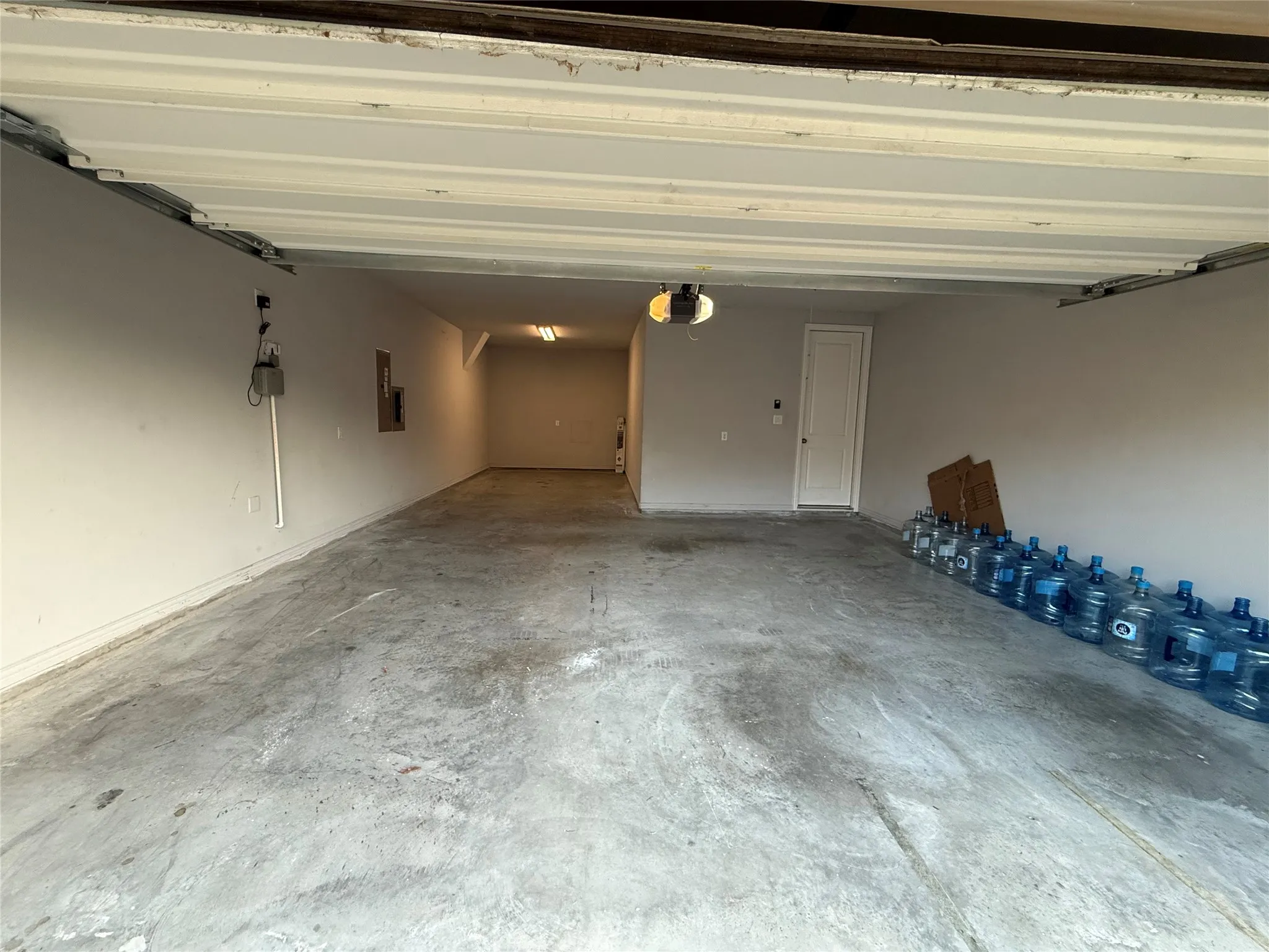Spacious garage with concrete flooring, painted walls, and a built-in overhead garage door opener