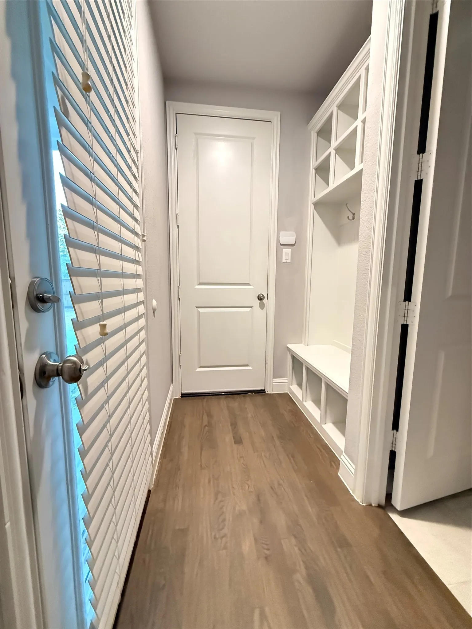 Wood-finish flooring with built-in storage bench and overhead cubbies