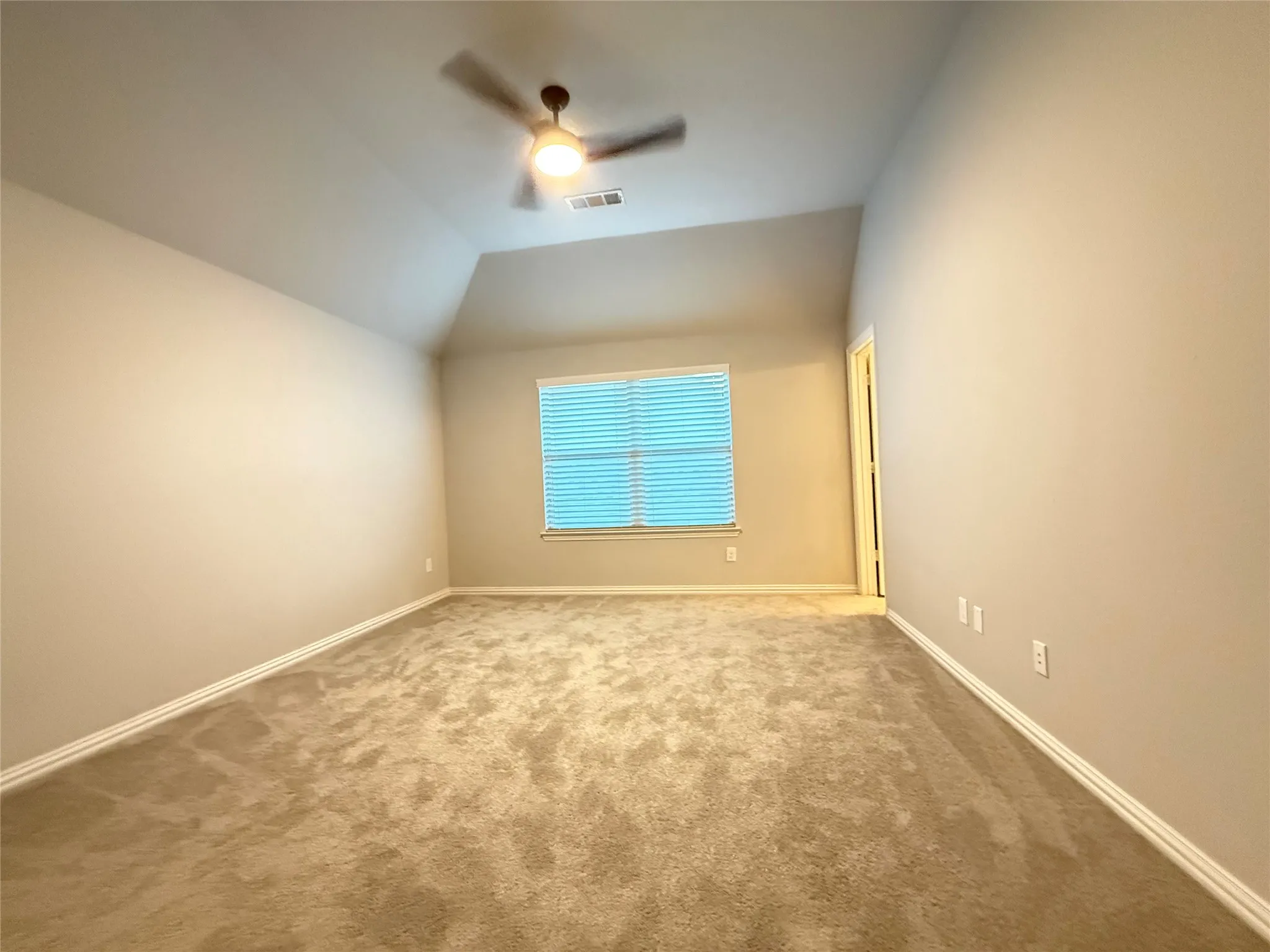 Vaulted ceiling, ceiling fan, carpeted flooring, window with blinds, and painted walls