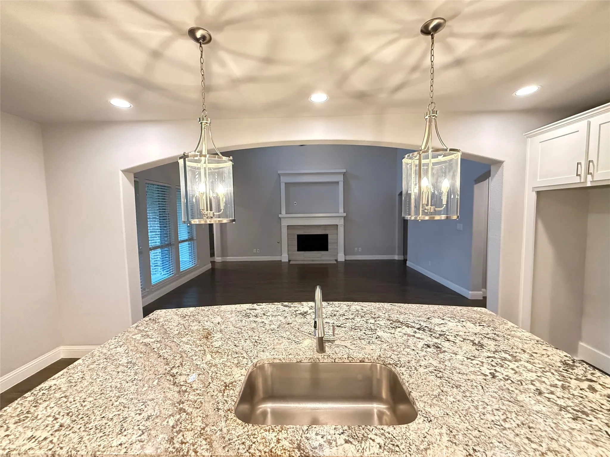 Kitchen island featuring a stainless steel sink and speckled countertop