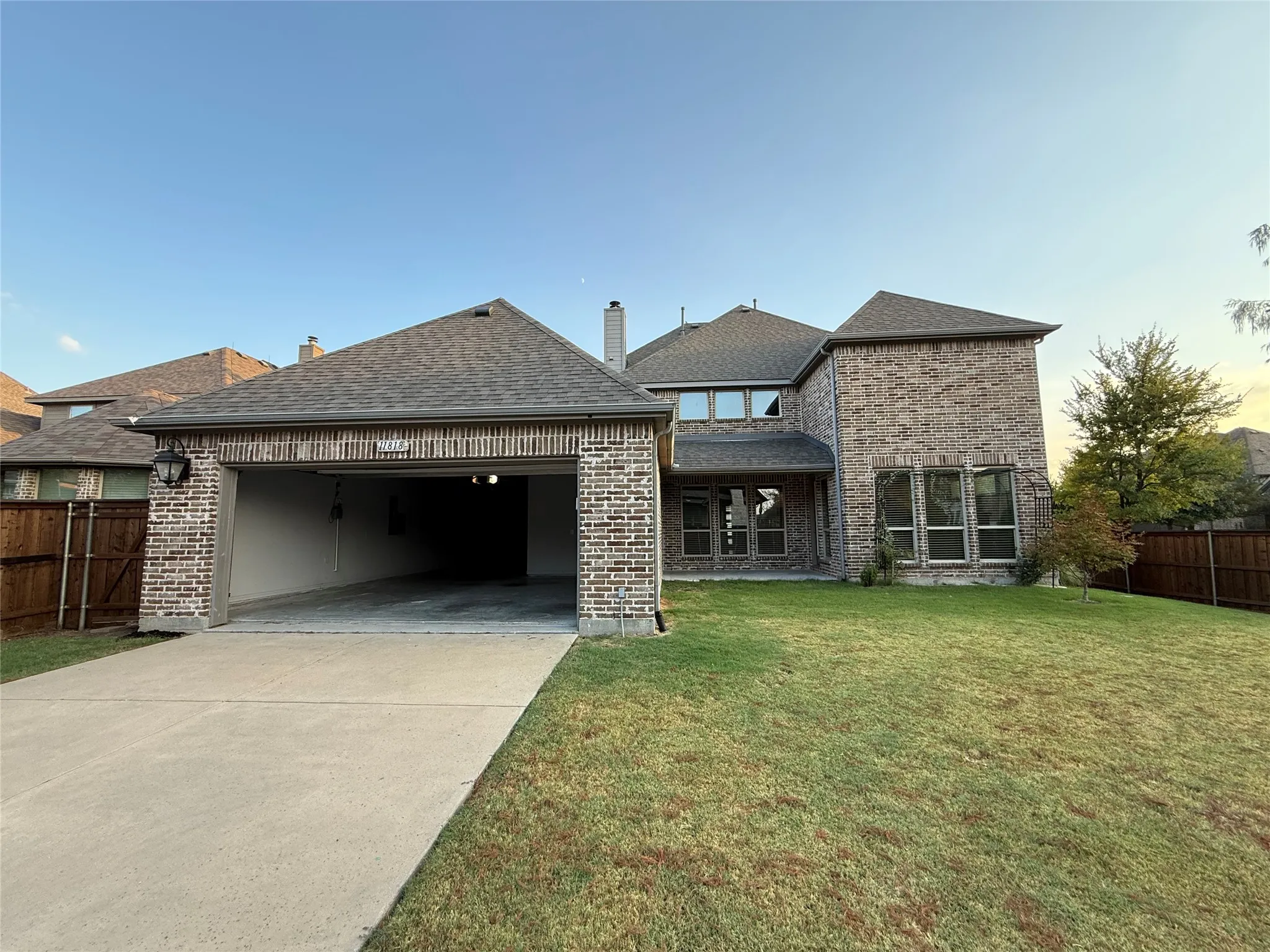 Brick exterior with a multi-level roofline, attached garage, and multiple large windows