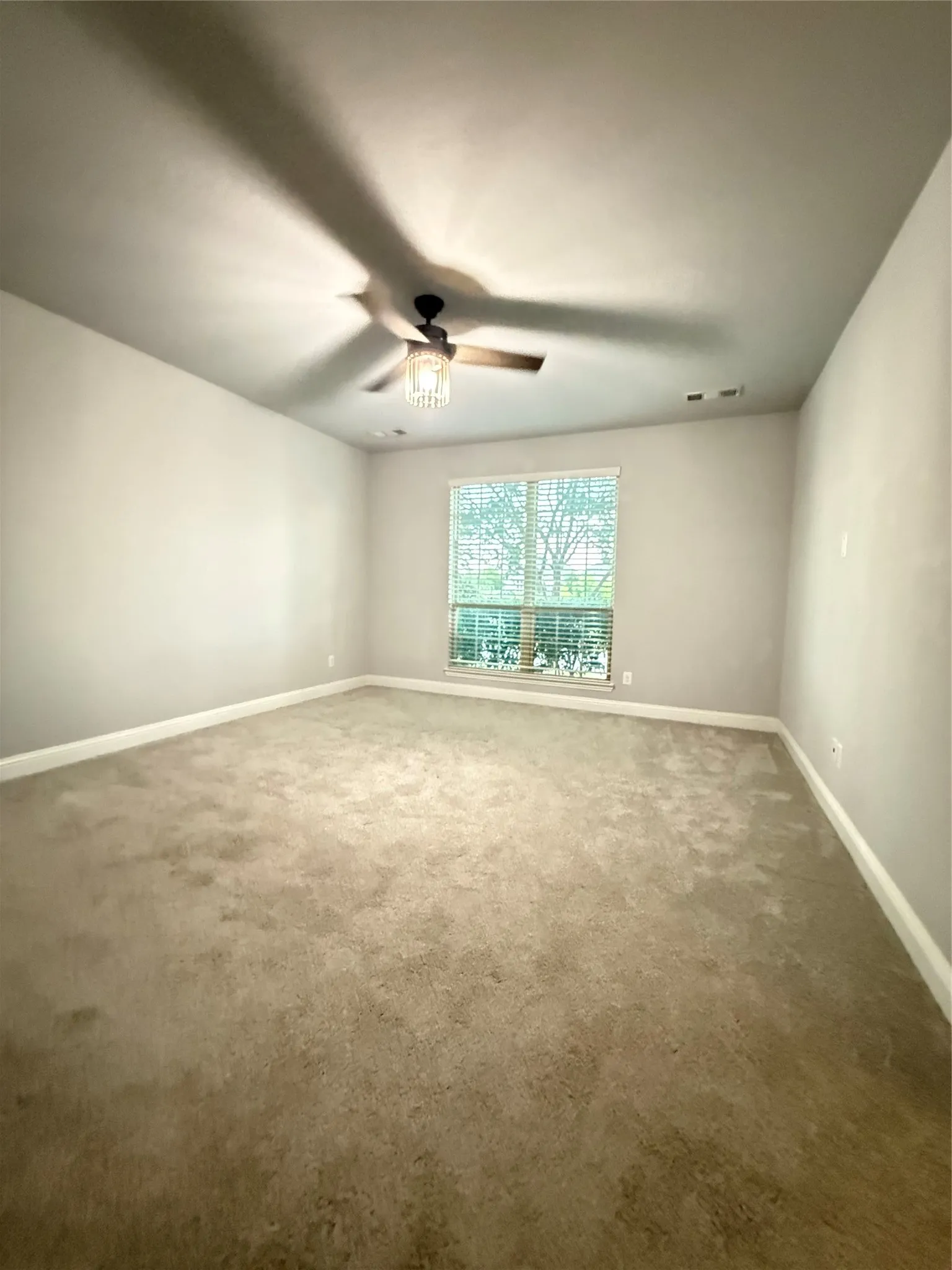 Recessed window with blinds, ceiling fan, and wall-to-wall carpeting