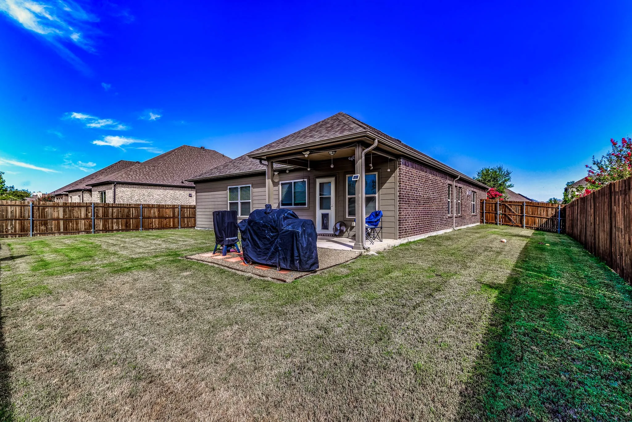 Rear view of house and a spacious yard and covered patio